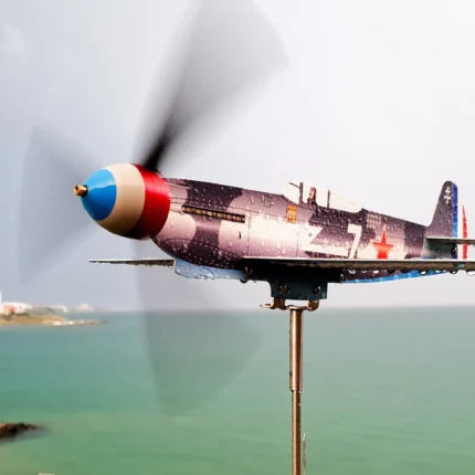 Weatherproof Yak9 stainless steel wind sculpture spinning on a seaside balcony after rain