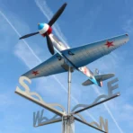 Installed Yak9 weathervane and kinetic wind spinner seen from below against the sky