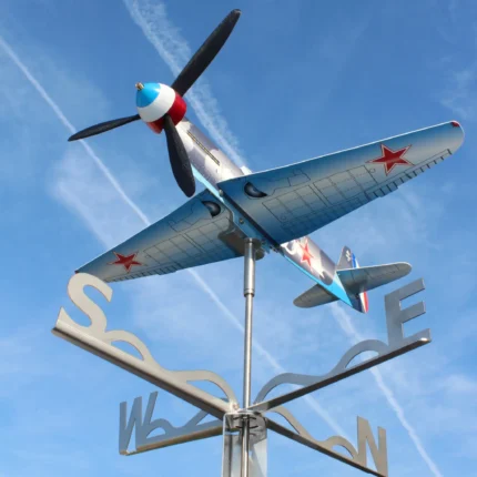 Installed Yak9 weathervane and kinetic wind spinner seen from below against the sky