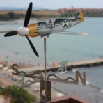 Ветропоказател и самолет Messerschmitt Bf109 на терасата пред морето функционира като кинетична украса на открито