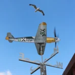 Ветропоказател и вятърна въртележка Bf 109 на фона на небето с летяща чайка