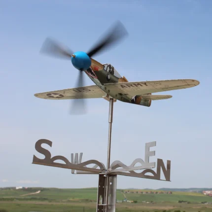 Stainless Steel P39 fighter aircraft model functioning as a garden weathervane in an open landscape environment