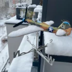 Weather resistant stainless steel Bell P39 Airacobra wind driven model covered in winter snow